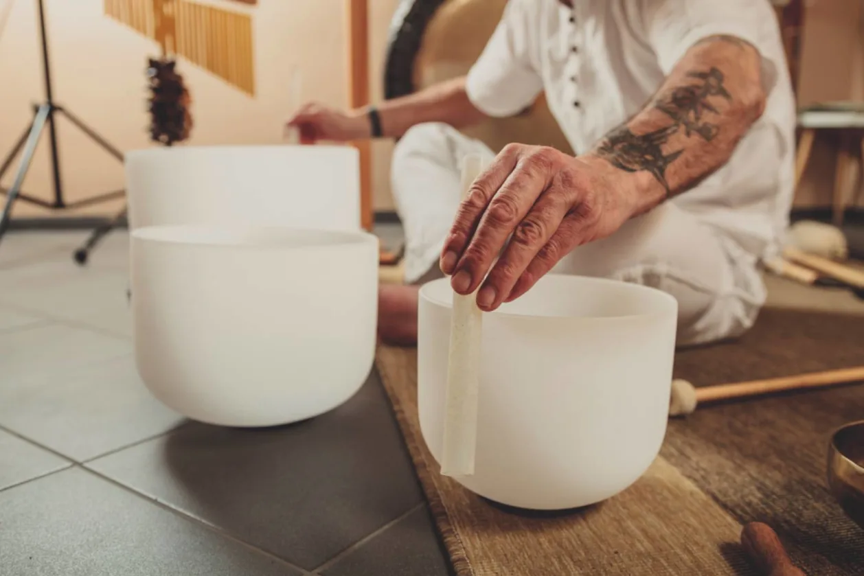 Man playing crystal singing bowls